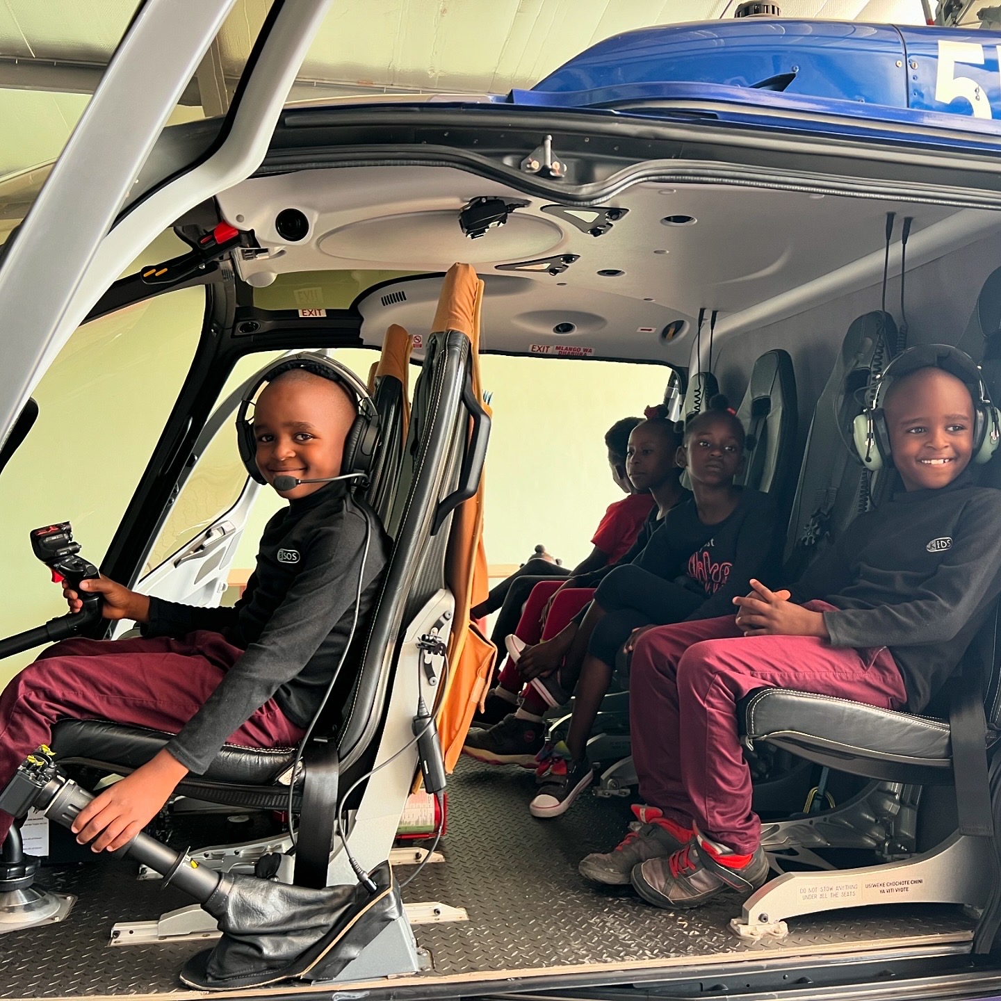 Children from local orphanage exploring Tropic Helicopters' Tango Tango Zulu hangar in Arusha.